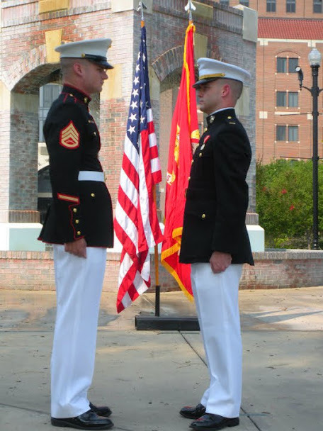 Two Marines in dress blues exchanging first salute