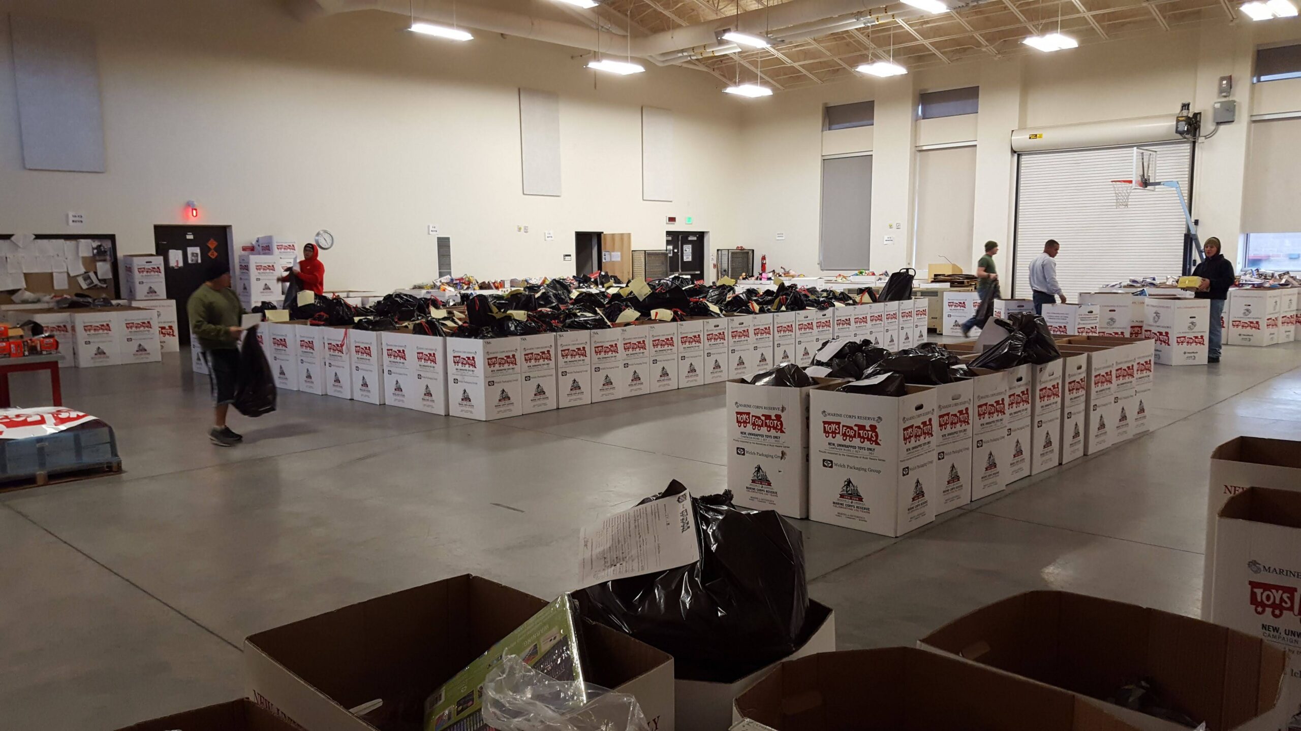 Toys for Tots distribution center with rows of white collection boxes